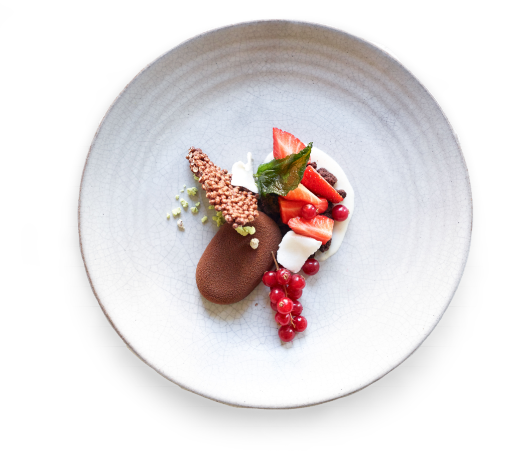 Ein plattiertes Gourmet-Dessert mit Mousse au Chocolat, Erdbeeren, Johannisbeeren, Sahne und einer knusprigen Garnitur - perfekt für professionelles Catering für Events in Köln.