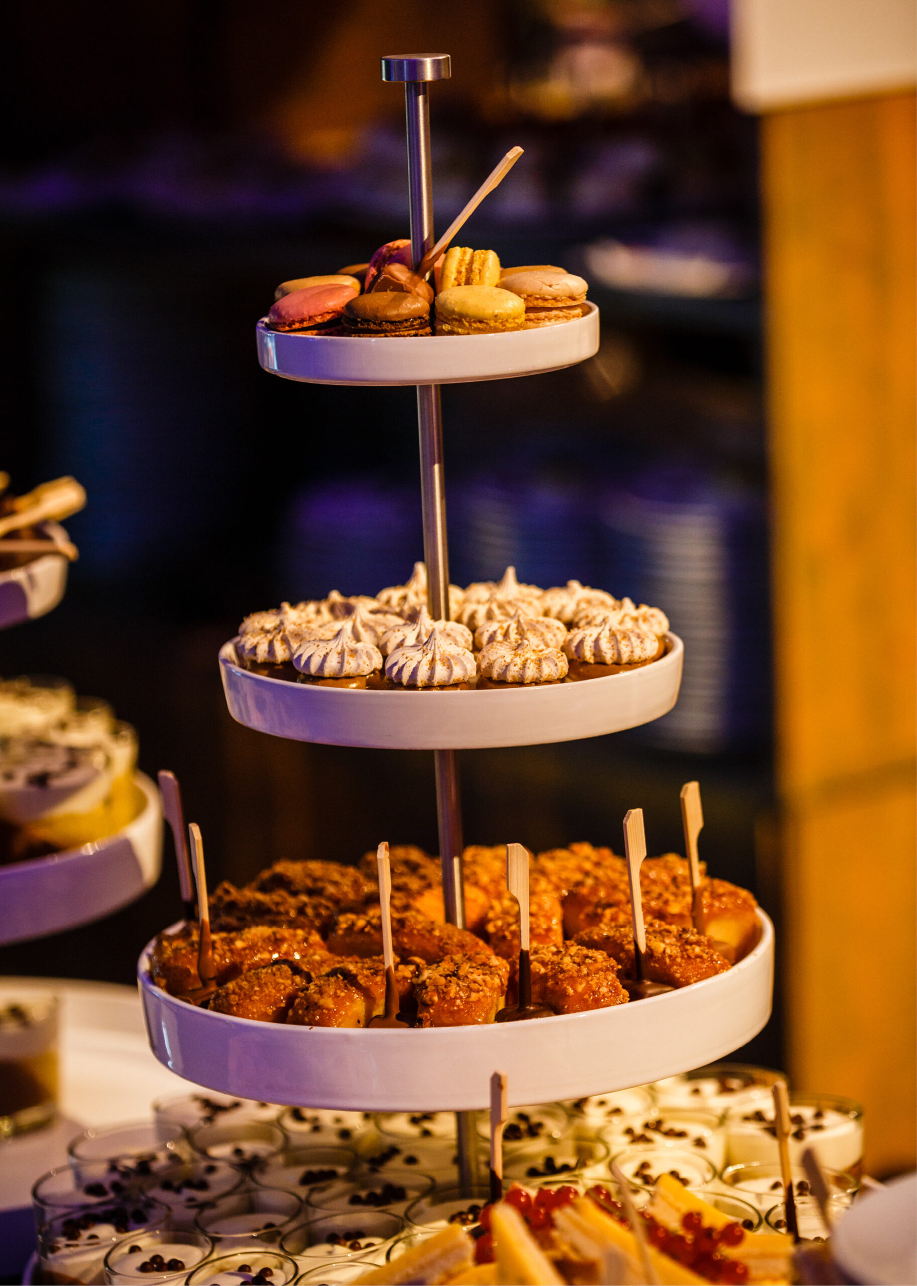Dreistöckiger Dessertstand mit verschiedenen Backwaren, darunter Macarons, Meringues und Torten.