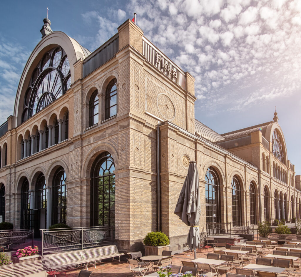 Historisches Backsteingebäude mit Rundbogenfenstern und Freisitz unter teilweise bewölktem Himmel - ideal, wenn Sie Eventlocations Köln mieten wollen für Ihre nächste Veranstaltung.
