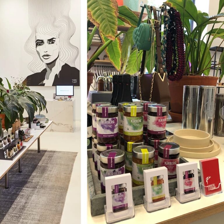 Moderne Boutique mit Pflanzen, Schönheitsprodukten, Schmuck und Kunst unter einer großen Frauenporträtzeichnung.