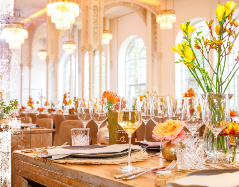 Vegane Veranstaltung in der Flora Köln mit edel gedeckten Tischen, opulenter Blumendekoration und luxuriösem Ambiente.