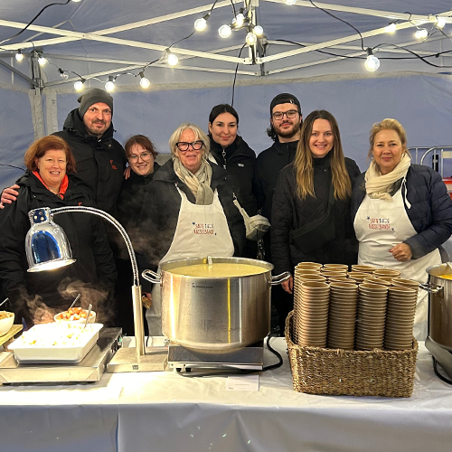 Bild von Kirberg-Mitarbeitern, die ehrenamtlich Essen für bedürftige Familien beim Martinszug der Satten Rasselbande ausgeben.